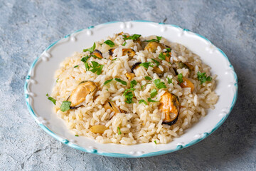 Mussel rice pilaf. Rice with mussels on small white plate on ceramic. (Turkish name; midyeli pilav)