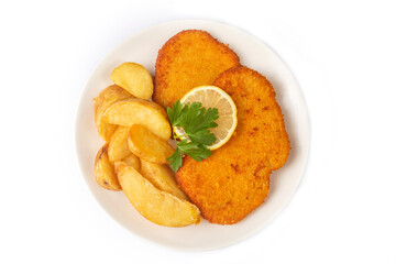 Chicken schnitzel with sauce, fried potatoes and lemon in a plate