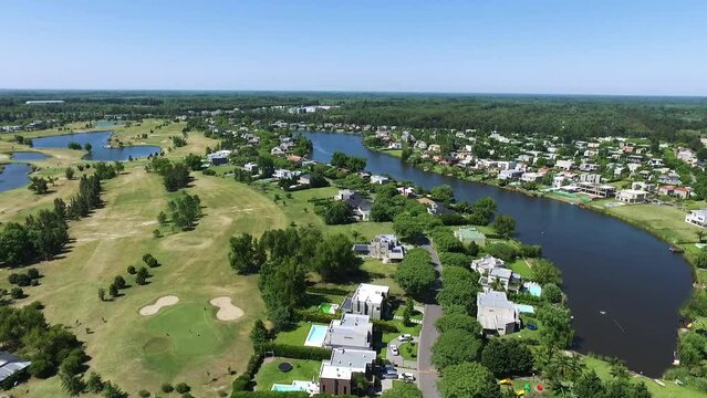 Residential. Aerial view of the private neighborhood and country club. View of the river flowing across the countryside houses and golf course in a sunny day. 