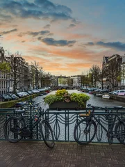 Schilderijen op glas Cycles and canal with dutch buildings in Amsterdam, Netherlands © Arnold