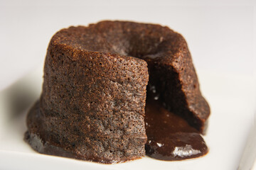 chocolate petit gateau, open with the filling dripping. White background