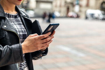 Cuadro cerrado a las manos de una chica con un teléfono móvil escribiendo