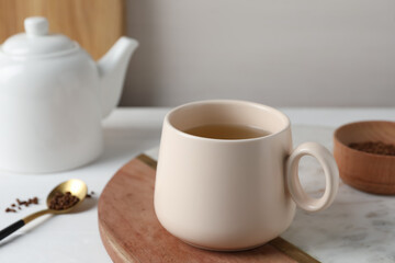 Fototapeta na wymiar Cup of aromatic buckwheat tea and granules on white table