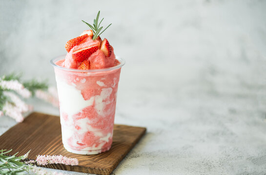 Closeup fresh strawberry milkshake, smoothie and fresh strawberries topping on stone table background. Healthy food and summer drink concept.