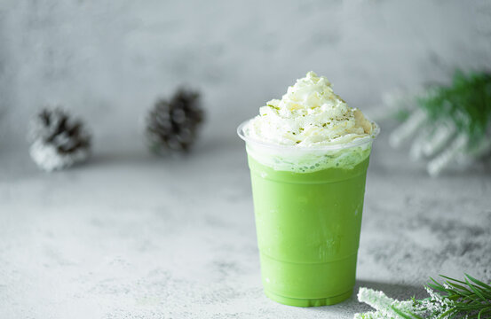 Iced green matcha latte tea and milk in glass on stone table background. Traditional japanese drink  and beverage concept.