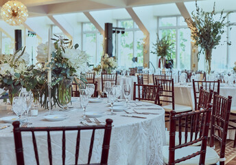 Luxury Beautiful Stylish Romantic Greens and Whites Fresh Flower decorations of guest tables at the wedding venue dinner celebration set up