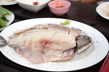 Fresh Gray pomfret, Chinese silver pomfret fish cut into pieces arranged in a white plate topped...