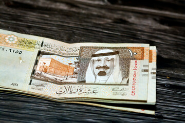 Stack of Saudi Arabia 10 SAR ten Saudi riyals cash money banknote with the photo of king Abdullah...