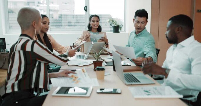 Diverse group of businesspeople passing paperwork during meeting in office boardroom. Ambitious colleagues analysing reports and documents while planning and brainstorming strategies in startup agency