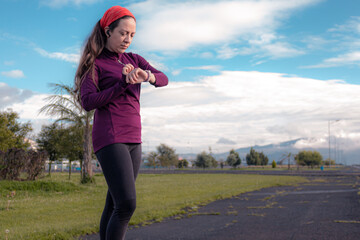young sporty woman practicing inline skating in an urban setting. Prepare sportwatch and headphones