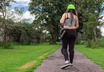 young sporty woman walking with line skates, ready to practice skating.