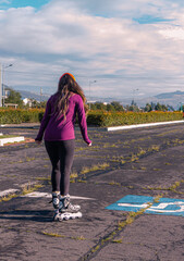 young sporty woman practicing inline skating in an urban setting. Rolling skate in a sunny morning