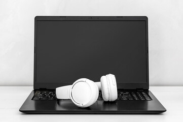 Laptop with bluetooth headphones at workplace.
