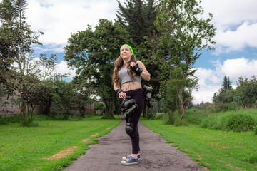 young sporty woman walking with line skates, ready to practice skating.