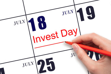 Hand drawing red line and writing the text Invest Day on calendar date July 18. Business and financial concept.