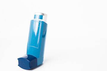 Blue asthma inhaler with blank label isolated on white background. Pharmaceutical product is used to treat or prevent asthma attack. Health and medical concept.