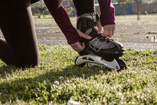 young sporty woman practicing inline skating in an urban setting. Preparing herself to skate.