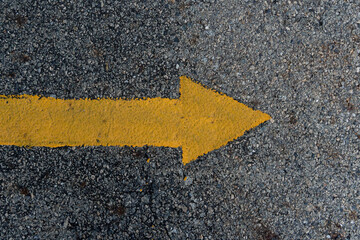 Above view of arrow sign pointing forward on asphalt road. For transport background and textured.