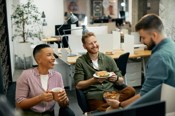 Multiracial group of happy entrepreneurs have fun while talking during lunch break in office.