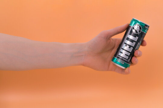 Budapest, Hungary - May 5, 2022: Green Hell strong focus energy drink on orange background. Vitality. Muscle. Force. Concentration. Charge. Effect. Life. Activity
