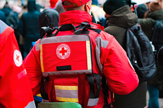 Kyiv, Ukraine - Jun 25, 2022: A emergency medic assistant in a red uniform stands outdoor on the street during the protest. Medicine. Rescue. Person. Paramedic. Urgency. Assistance. Doctor. Help