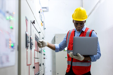Electrical engineer working in control room.  Electrical engineer man checking Power Distribution Cabinet in the control room