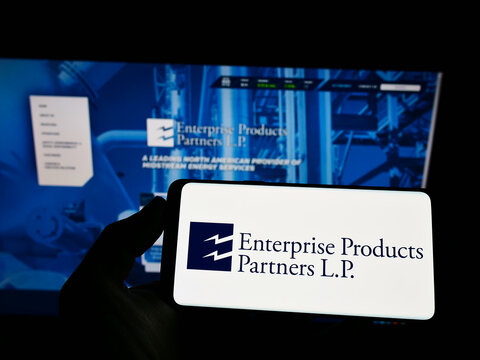 Stuttgart, Germany - 02-05-2022: Person holding smartphone with logo of pipeline company Enterprise Products Partners L.P. on screen in front of website. Focus on phone display.