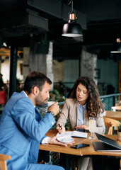 Female entrepreneur having business meeting with her coworker in cafe.