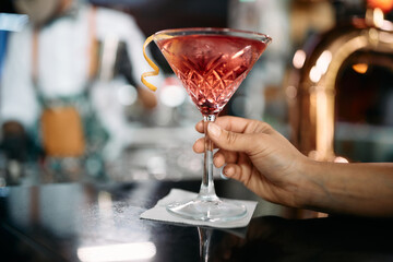 Close up of woman having cocktail in bar.