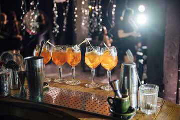 Glasses with different cocktails. Long and short cocktails at a party with disco lighting