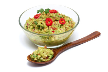 Healthy vegetarian organic guacamole Mexican dip sauce served in glass bowl with nachos or tortilla chips isolated on white background