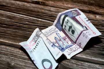 Crumpled Saudi Arabia money of 5 SAR five riyals isolated on wooden background, wrinkled 5 Saudi...