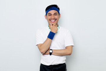 Portrait of smiling young Asian sportman in blue headband and white t-shirt with headphones, feels confident and joyful isolated on white background. Workout sport concept