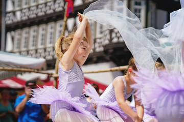 Little preschool girl dancing ballet at city festival. Beautiful happy child ballerina in tutu dress