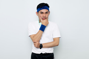 pensive young Asian sportman in blue headband and sportswear white t-shirt with headphones, serious face thinking about a question, thoughtful about confusing idea isolated on white background