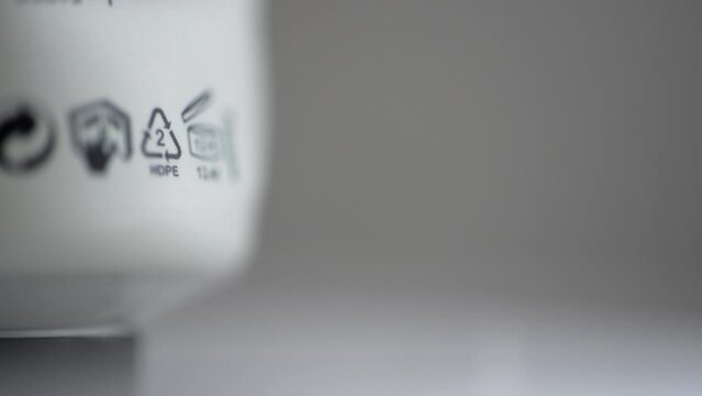 4k Closeup view of recycling signs 02 hdpe and others on white product or garbage packaging spbd. Low pressure polyethylene: cans, bottle caps, bottles for cosmetics and household chemicals. It can be