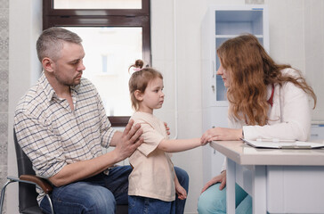 Fototapeta premium a female doctor carefully examines a little girl patient.