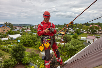 A specialist is repairing the roof. Rope access