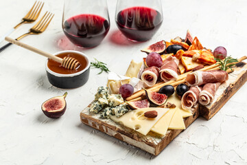 Appetizers table with italian antipasti snacks and wine in glasses. cheese, ham, nuts, fruit, bread...