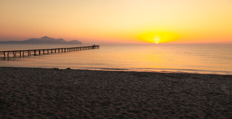 Wooden pier in the beach. Wood bridge in the beach. Sunset in the beach, golden hour. Mallorca island, 