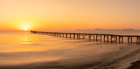 Obraz premium Wooden pier in the beach. Wood bridge in the beach. Sunset in the beach, golden hour. Mallorca island, 