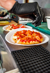 hand of chef baker making mini pizza at kitchen. The process of making pizza. cooking italian pizza
