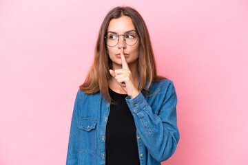 Young caucasian woman isolated on pink background showing a sign of silence gesture putting finger in mouth