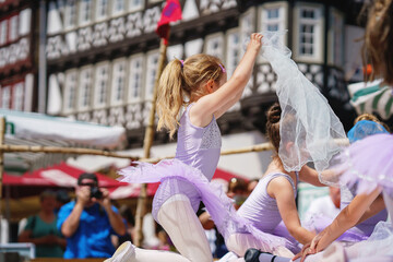 Little preschool girl dancing ballet at city festival. Beautiful happy child ballerina in tutu dress