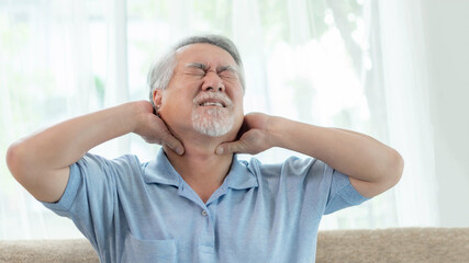 Senior Asian man , old man he wake up and sat on the bed , He had pain in the nape of his neck caused by sleeping on a pillow that is not correct posture - Senior people unhealthy diseased concept
