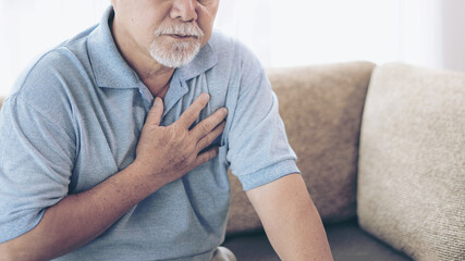Senior male asian suffering from bad pain in his chest heart attack at home - senior heart disease - obrazy, fototapety, plakaty