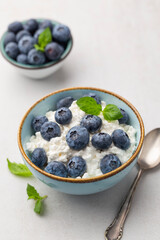 Cottage cheese with blueberry, fresh berries, keto healthy breakfast concept, top view.