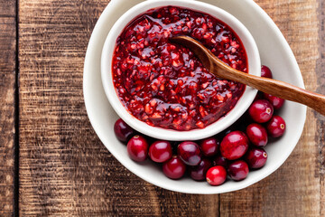 Red cranberries on wooden background. Brries in a bowl.