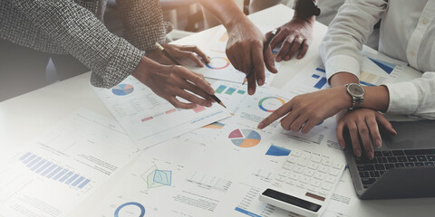 Group of business people meeting together Pointing to the graph assess business profits.