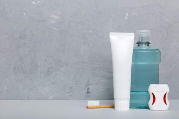 Mouthwash and other oral hygiene products on colored table top view with copy space. Flat lay. Dental hygiene. Oral care products and space for text on light background. concept